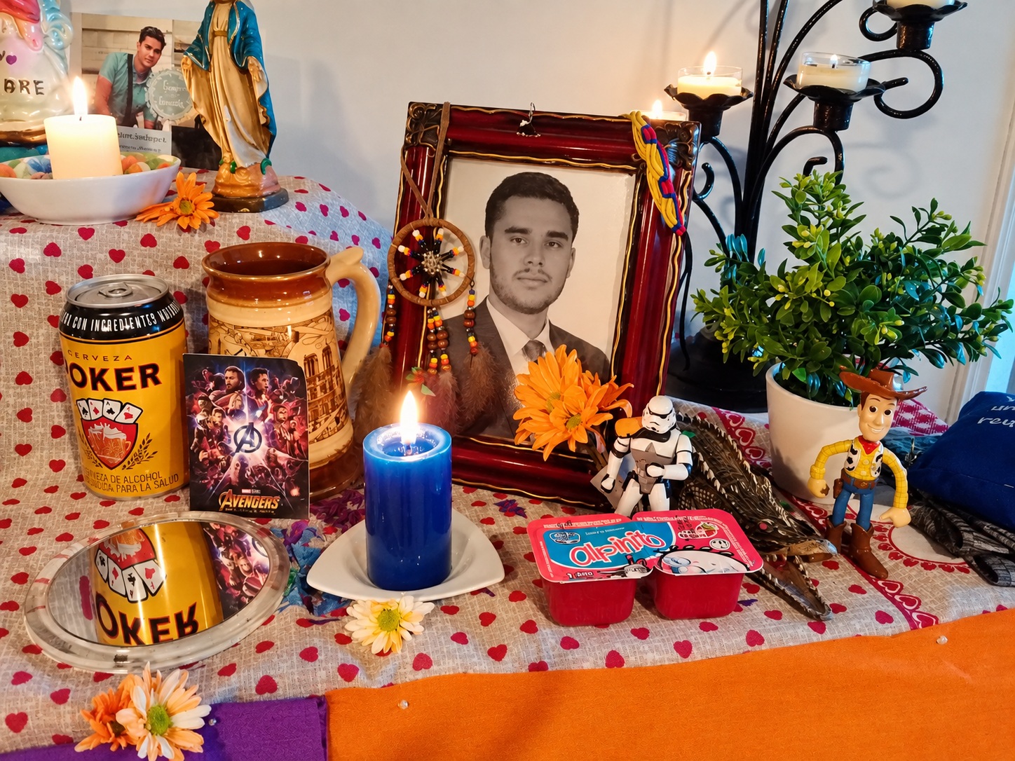 Altar familiar de recuerdo dedicado a Juanes, con una fotografía, velas, flores y objetos personales.
