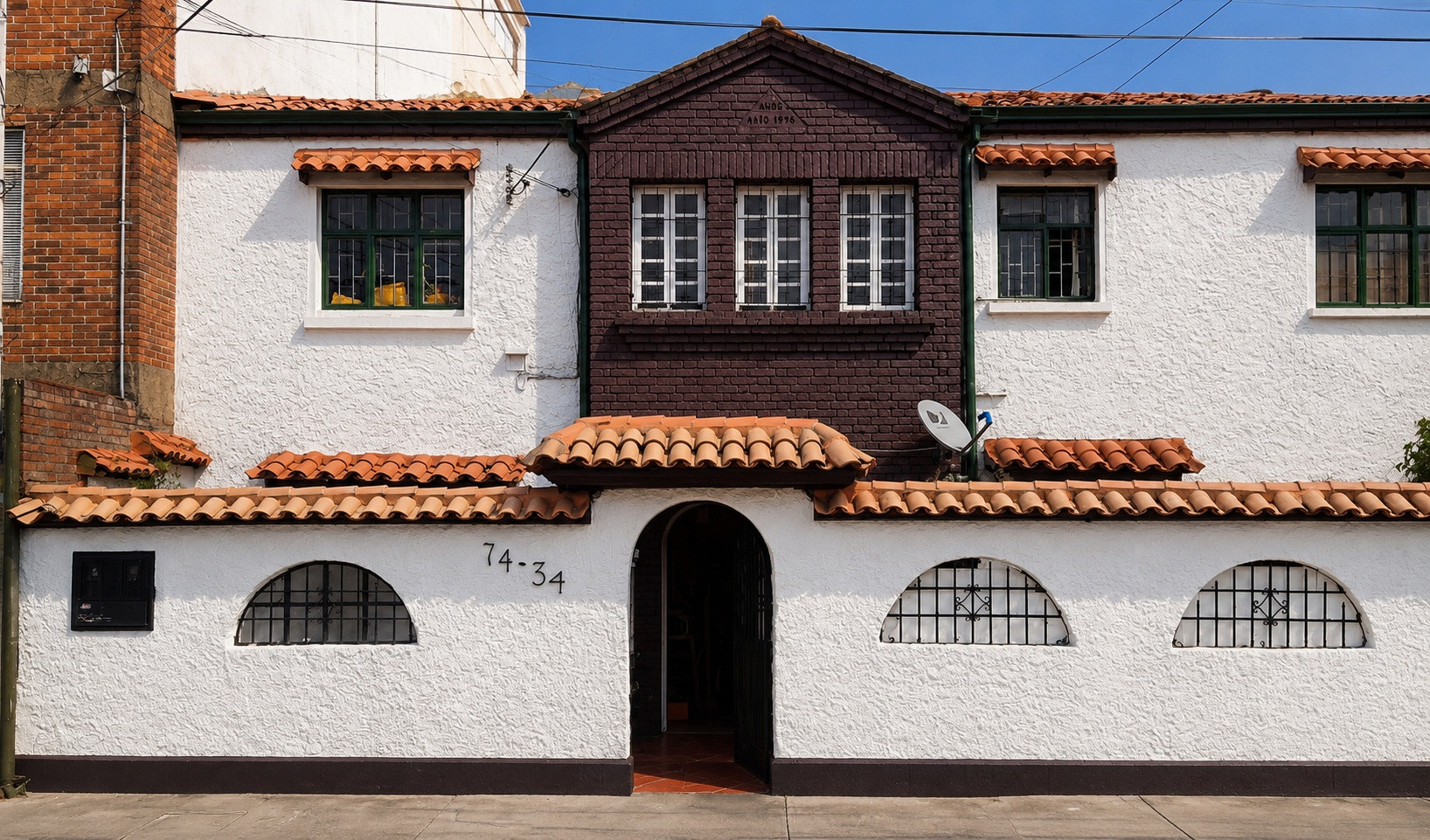 Fachada de la casa en la calle 74 con enredadera verde