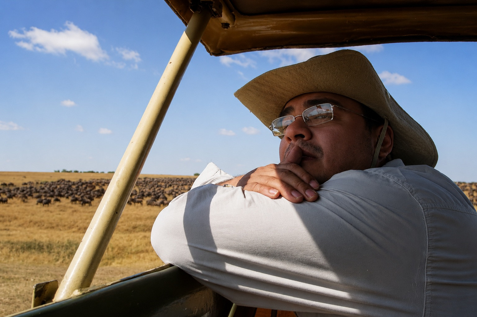 Jairo, con sombrero de safari, contempla desde la van la gran manada en la sabana