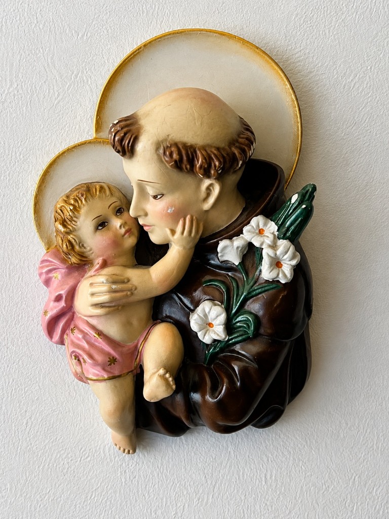 Relieve de San Antonio de Padua con el Niño Jesús y azucenas, colgado sobre la cabecera